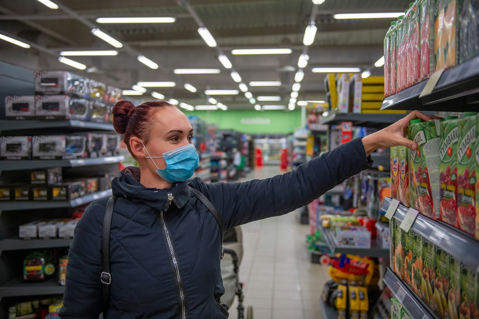 woman in black zip up jacket wearing blue face mask